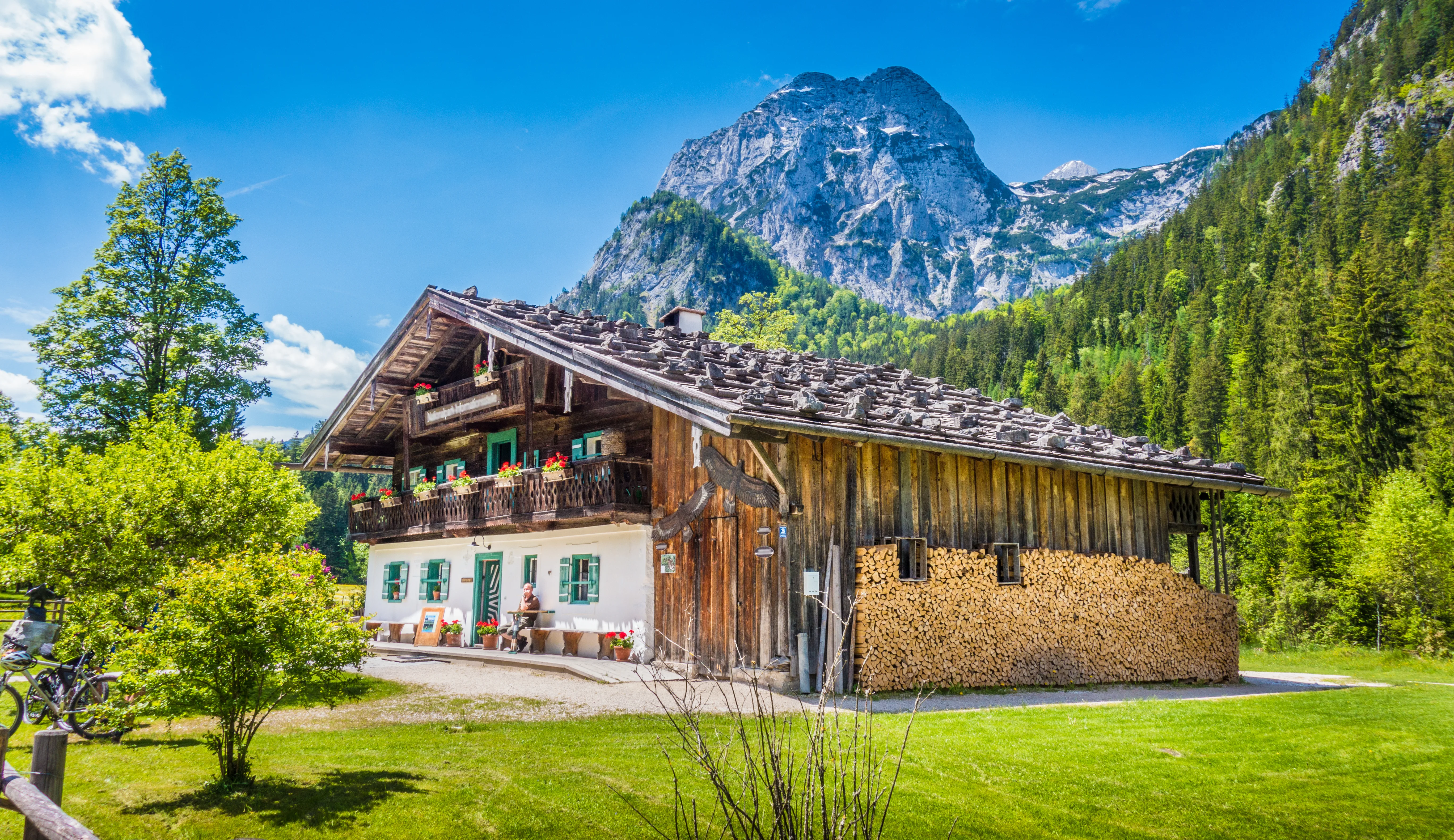 Traditionelles Bauernhaus mit Holzstapel im Berchtesgadener Land